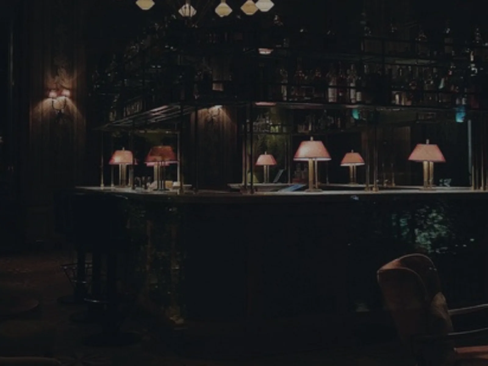 Bar d'un établissement de nuit, lampes allumées sur le comptoir