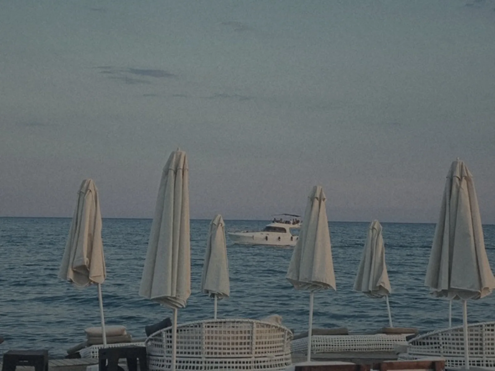 Parasols repliés au bord de la mer, au crépuscule