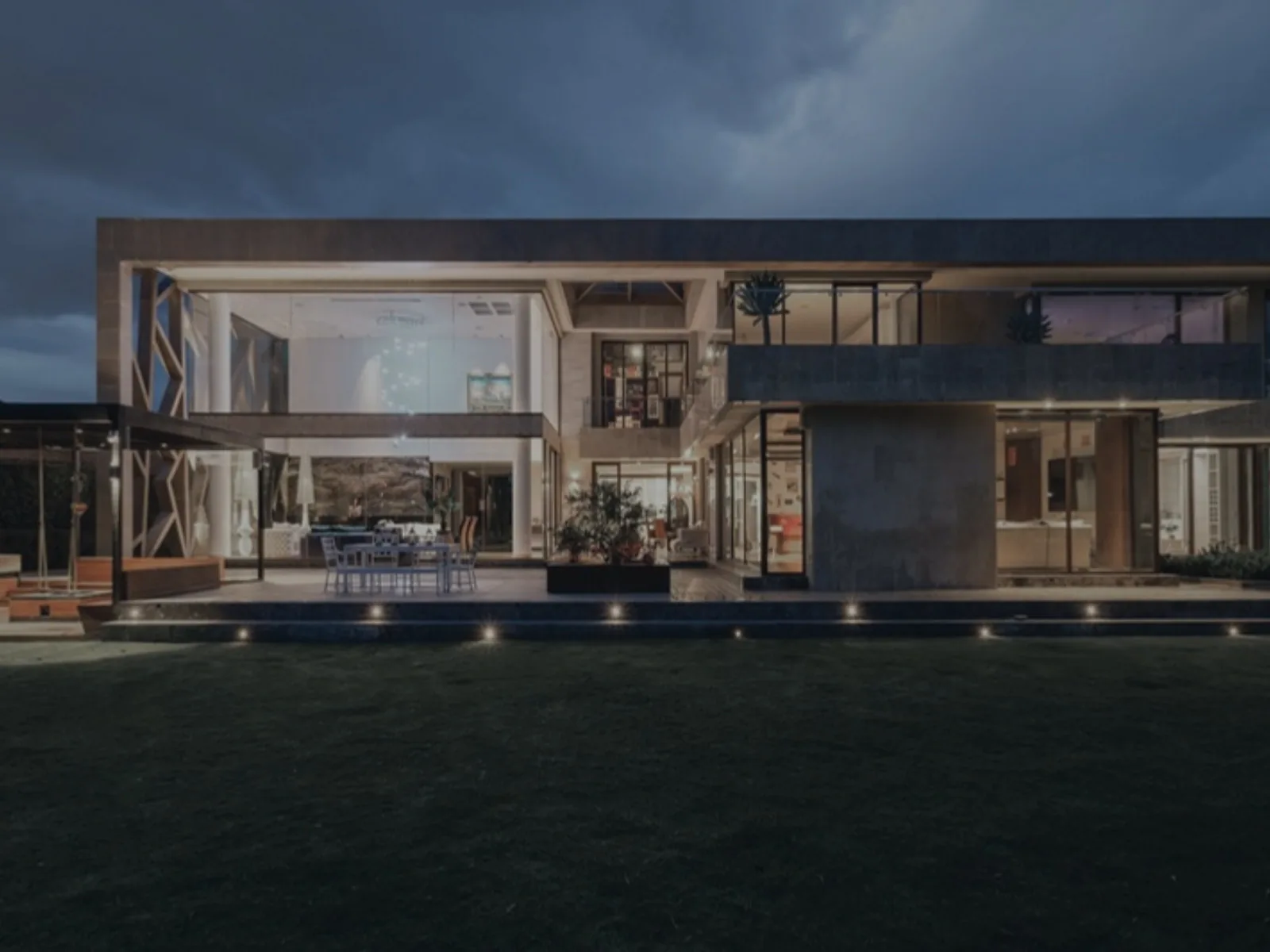 Villa contemporaine au crépuscule, façade vitrée et jardin